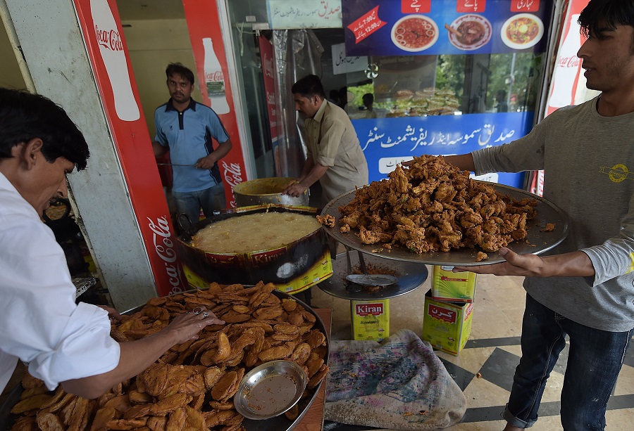 Pakistani bakers prepare Iftar food for Muslims breaking their fast on the first day of fasting month of Ramadan, at a market in Islamabad on June 7, 2016. Islam's holy month of Ramadan is celebrated by Muslims worldwide marked by fasting, abstaining from foods, sex and smoking from dawn to dusk for soul cleansing and strengthening the spiritual bond between them and the Almighty. / AFP / AAMIR QURESHI
